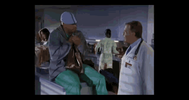 a man in scrubs talking to a doctor in a hospital