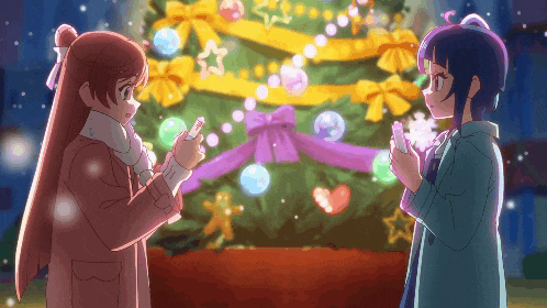 two girls standing in front of a christmas tree