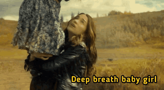 a woman is holding a child and the words deep breath baby girl are above her