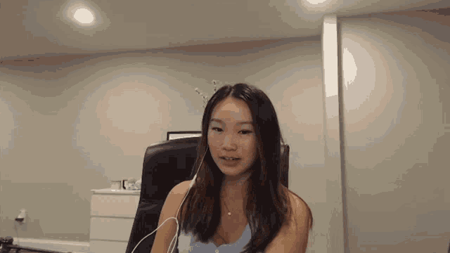a woman wearing headphones sits in a chair in a room