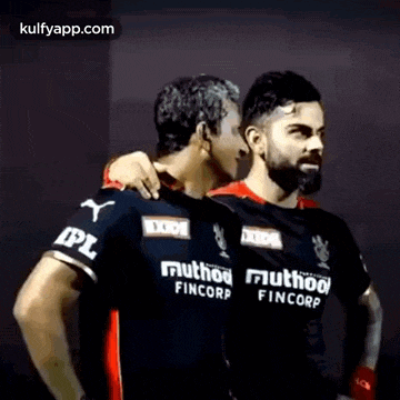 a couple of men standing next to each other .