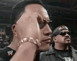 a man with a w on his shirt is covering his face