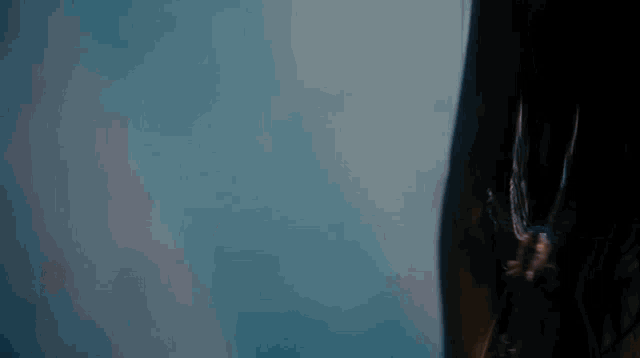 a close up of a person 's face against a blue sky .