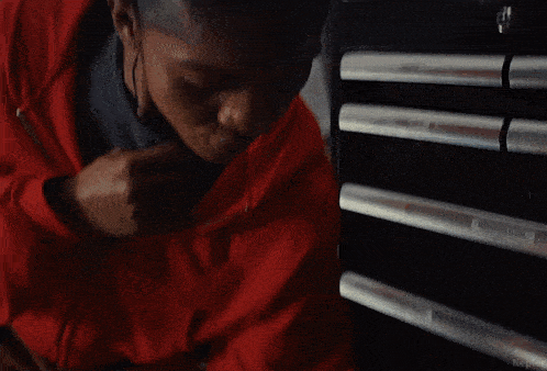 a woman in a red jacket holds a robotic hand with a barcode on it