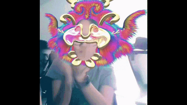a person is wearing a colorful mask with a dragon on it
