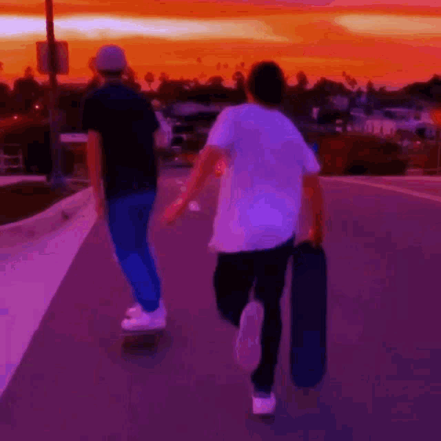 a man riding a skateboard down a street with a sunset in the background