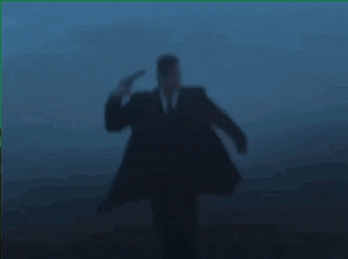 a man in a suit and tie is holding a gun to his head ..