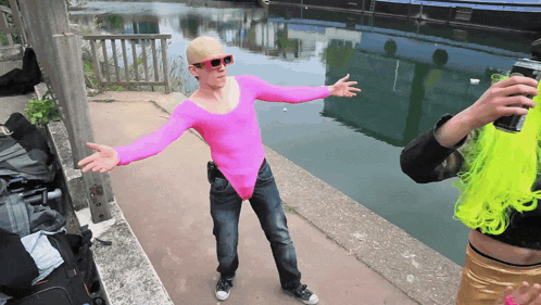 a man in a pink bodysuit is standing next to another man