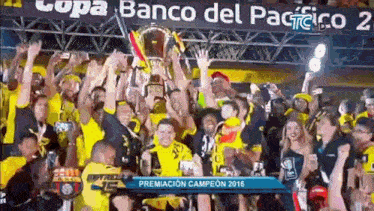 a group of people are holding a trophy in the air .