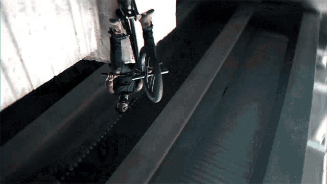 a man is doing a trick on a bike in a dark tunnel