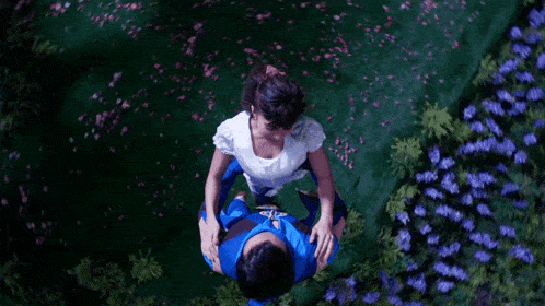 a man in a blue suit holds a woman in a white dress