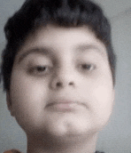 a close up of a young boy making a funny face .