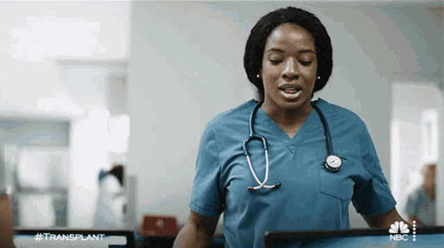 a nurse with a stethoscope around her neck is standing in front of a computer screen that says #transplant