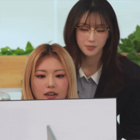 two women wearing glasses are looking at a computer monitor