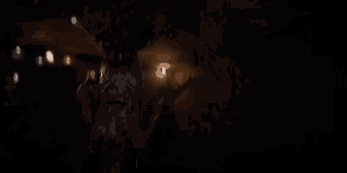 a dark room with christmas lights hanging from the ceiling