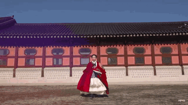 a woman in a red dress is standing in front of a building that says yoyo