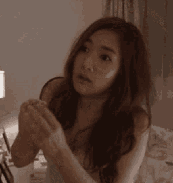 a woman in a white tank top is looking at something