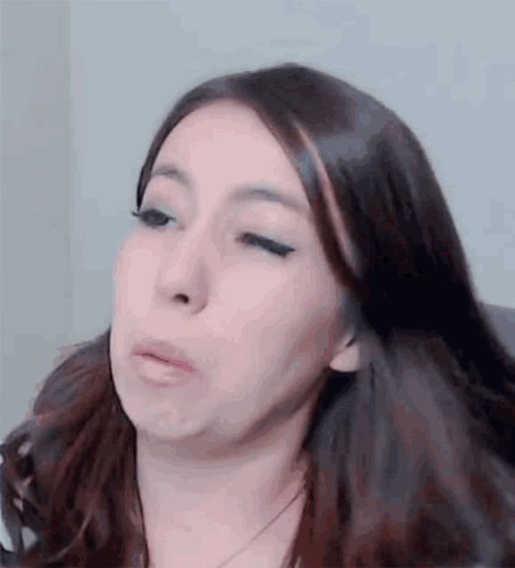 a close up of a woman making a funny face with her mouth open .