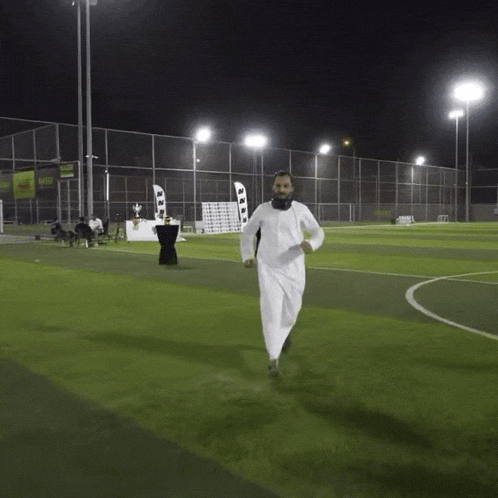 a man with a beard is running on a soccer field