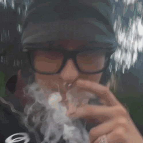 a man wearing glasses is smoking a cigarette