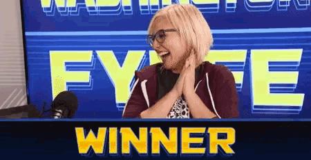 a woman is sitting in front of a microphone with the word winner behind her