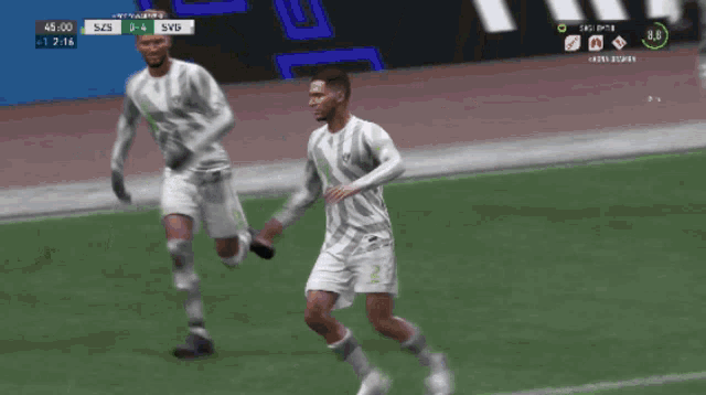 two soccer players are running on a field with a score of 5 to 4 on the screen