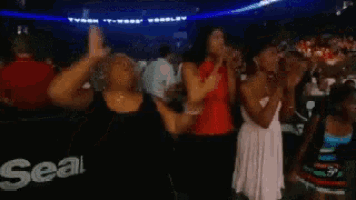 a group of women are dancing in front of a sears ad
