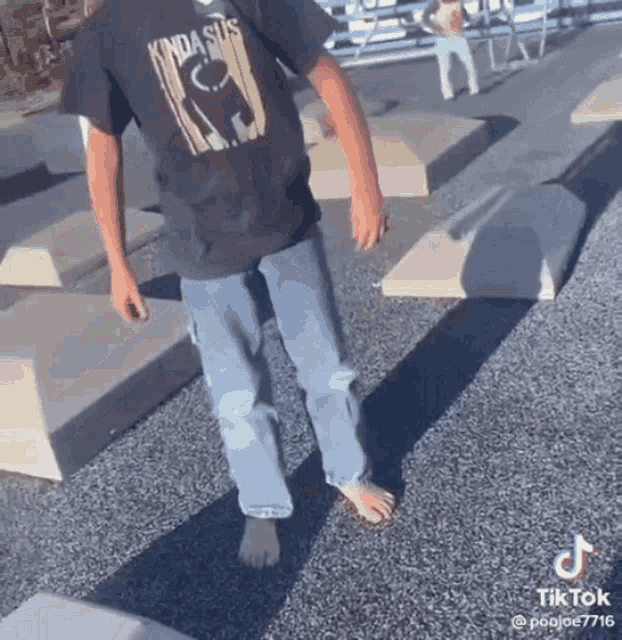 a person wearing a kinda sus t-shirt is walking barefoot