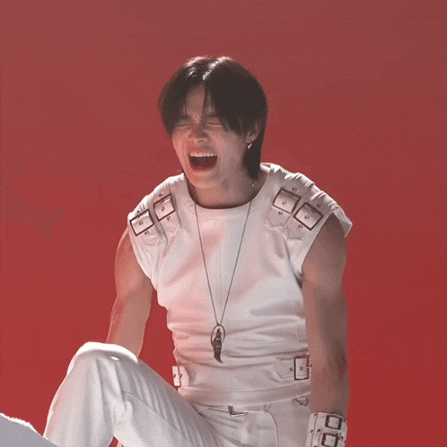 a man wearing a white vest and white pants screams with his mouth open