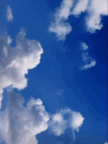 a blue sky with white clouds that look like a face