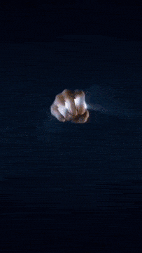 a person 's hand is reaching out towards a blue light