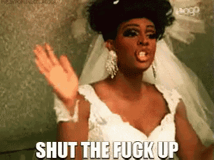 a woman in a wedding dress is making a funny face and saying `` shut the fuck up '' .