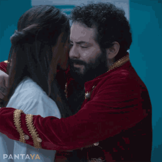 a man in a red jacket is hugging a woman in a white lab coat with pantaya written in the corner
