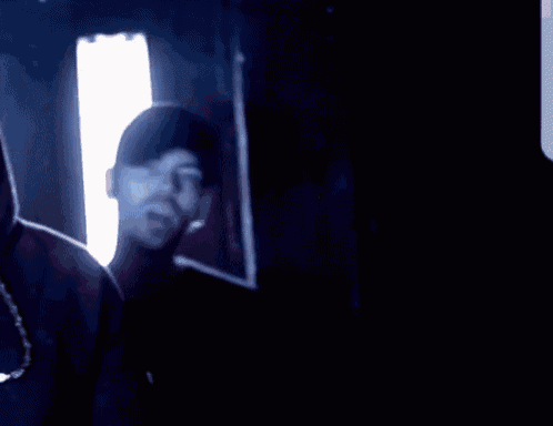 a man with a beard is standing in front of a blue light