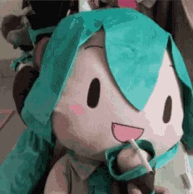 a person is holding a stuffed animal that looks like hatsune miku holding a cigarette .