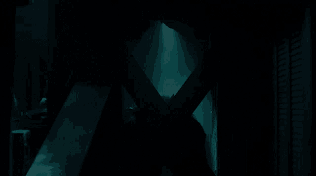 a dark room with a light shining through the door