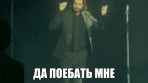 a blurry picture of a man singing into a microphone in a dark room with a foreign language caption