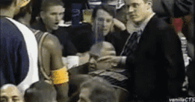 a man in a suit is talking to a man in a crowd