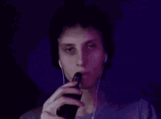 a man wearing headphones and a blue shirt is looking at the camera .