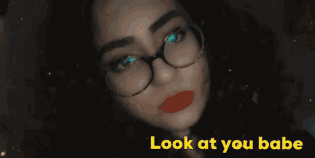 a close up of a woman wearing glasses with the words look at you babe behind her