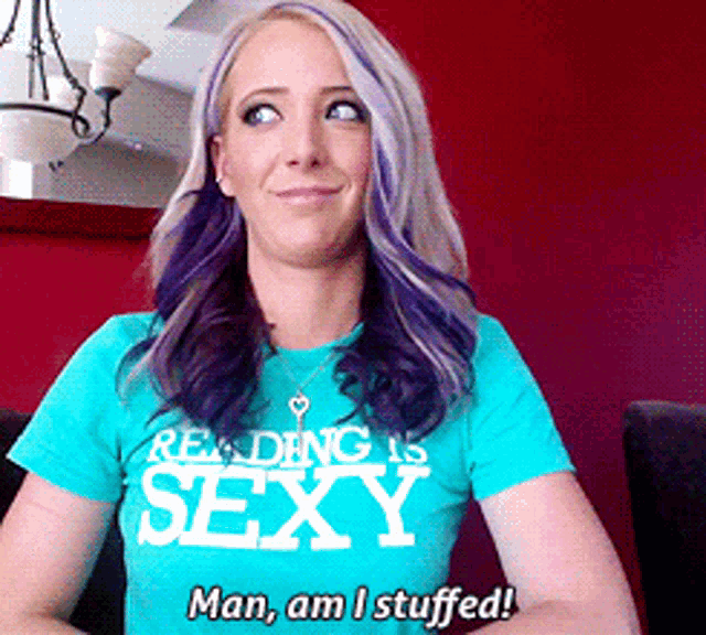 a woman wearing a reading is sexy t-shirt says man am i stuffed