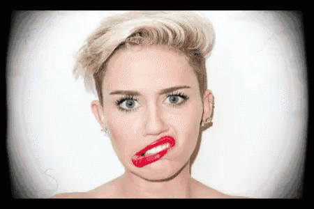 miley cyrus is making a funny face with her mouth open and red lipstick on her lips .