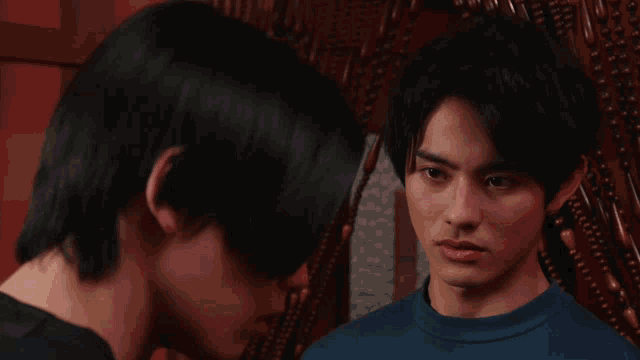 a man in a blue shirt is talking on a phone