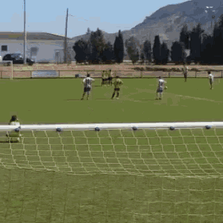 a soccer game is being played on a field with mountains in the background