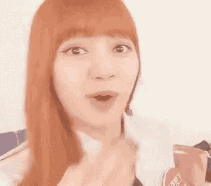 a woman with long red hair is making a funny face .