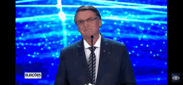 a man in a suit and tie is giving a speech into a microphone .