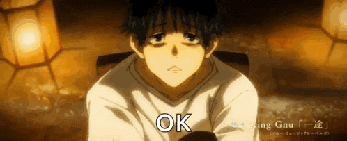 a man in a white shirt is sitting down and the word ok is on the bottom right