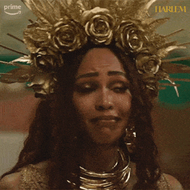 a woman wearing a crown of gold roses is crying and the word prime is on the bottom right