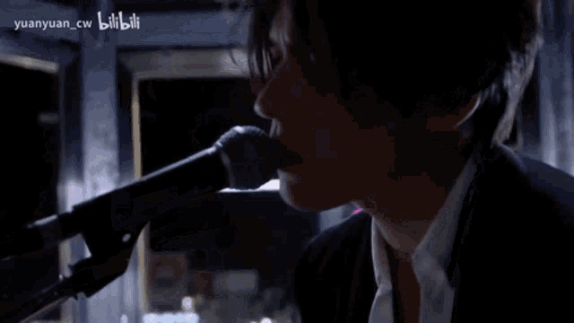 a man singing into a microphone with the words reality written on the bottom