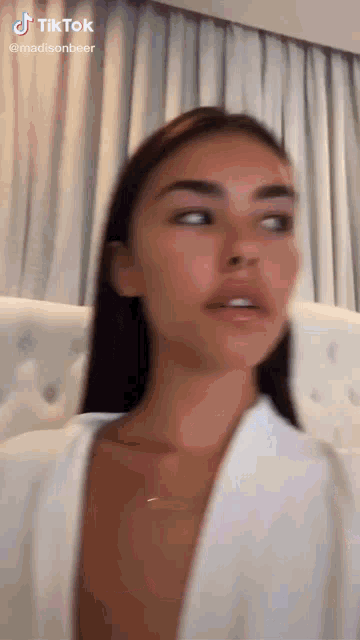 a close up of a woman 's face with a white shirt on .